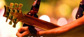 Homem tocando guitarra com garrafa de cerveja