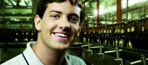Trainee da Ambev com umas garrafas de Skol no fundo