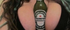 Garrafa de heineken no meio de peitos