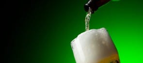 Garrafa botando cerveja numa tulipa
