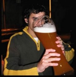 Rapaz tomando um copo gigante de cerveja