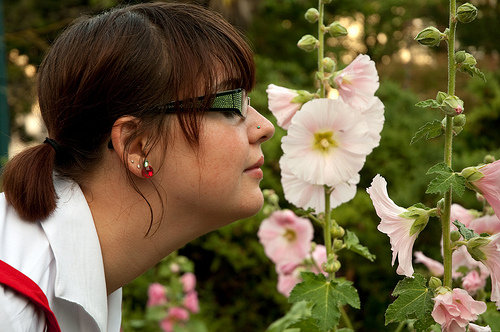 Mulher cheirando uma flor