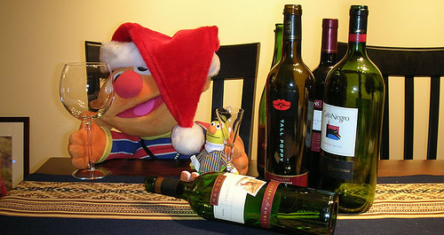 Boneco com gorro de natal e vinhos