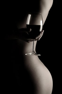 Mulher nua segurando taça de vinho