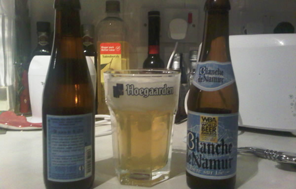 Garrafas da cerveja Blanche De Namur no copo da Hoegaarden