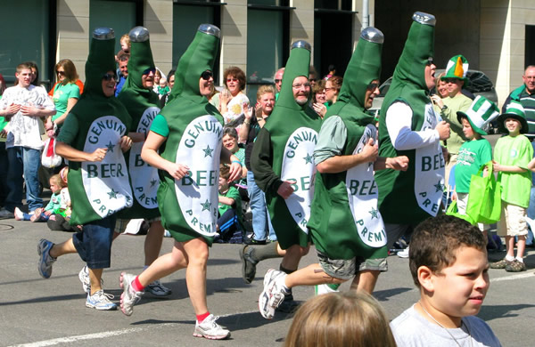 Pessoas fantasiadas de garrafas verdes da Guinness