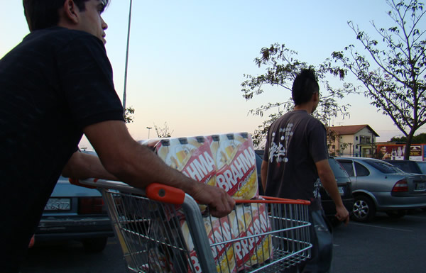 Homens levando carrinho de compras cheio de cerveja