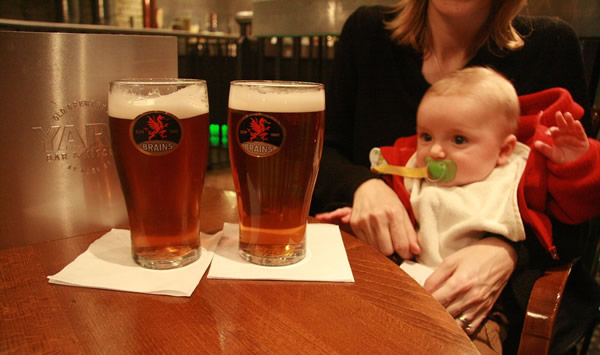 Bebê olhando copos de cerveja