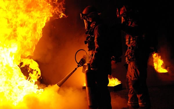 Bombeiros apagando fogo com extintor