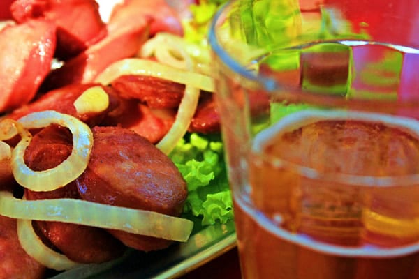 Porção de Linguiça Calabresa acebolada com um copo de cerveja