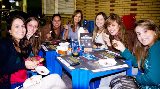 Mulheres bebendo e comendo num boteco