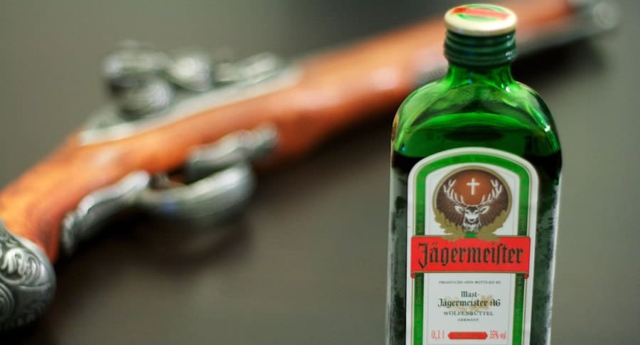 Arma e uma garrafa de Jagermeister