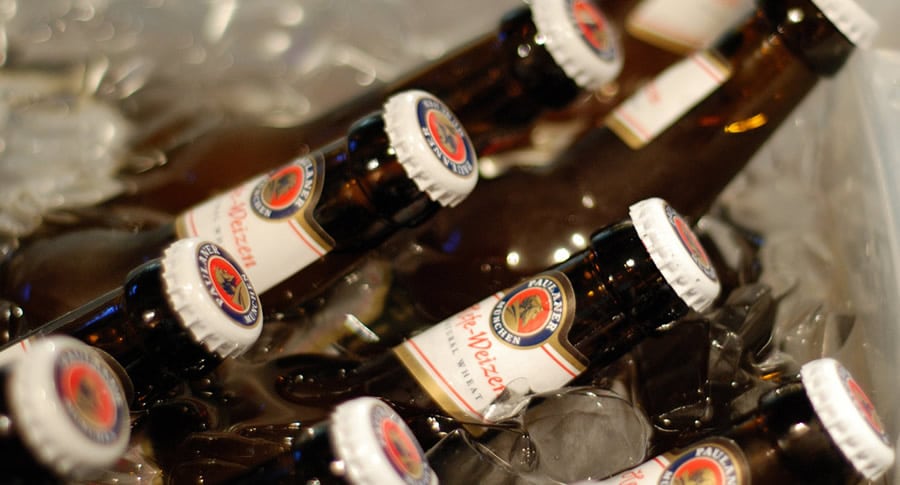 Garrafas da cerveja Paulaner Hefe Weizen no gelo