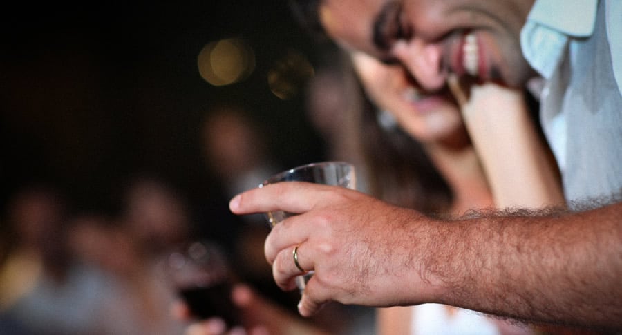 Homem sorrindo segurando um copo de cerveja