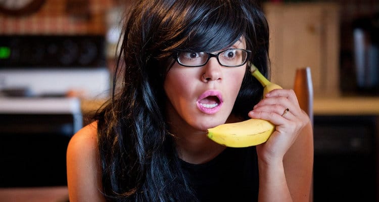 Mulher falando no telefone com uma banana