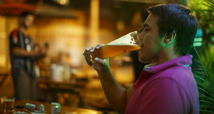 Morador bebendo cerveja no Bistrô Estacao R&R no Complexo do Alemão