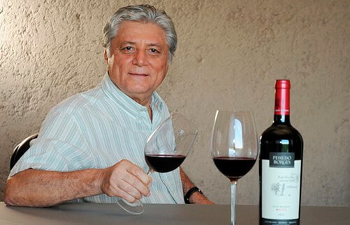 Euclides Penedo Borges segurando taças de vinho