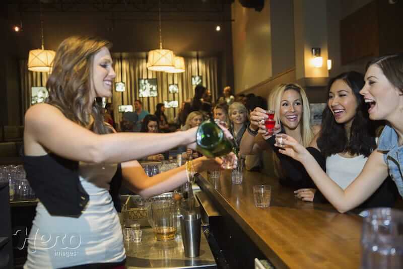 mulheres bebendo em pé e bartender mulher