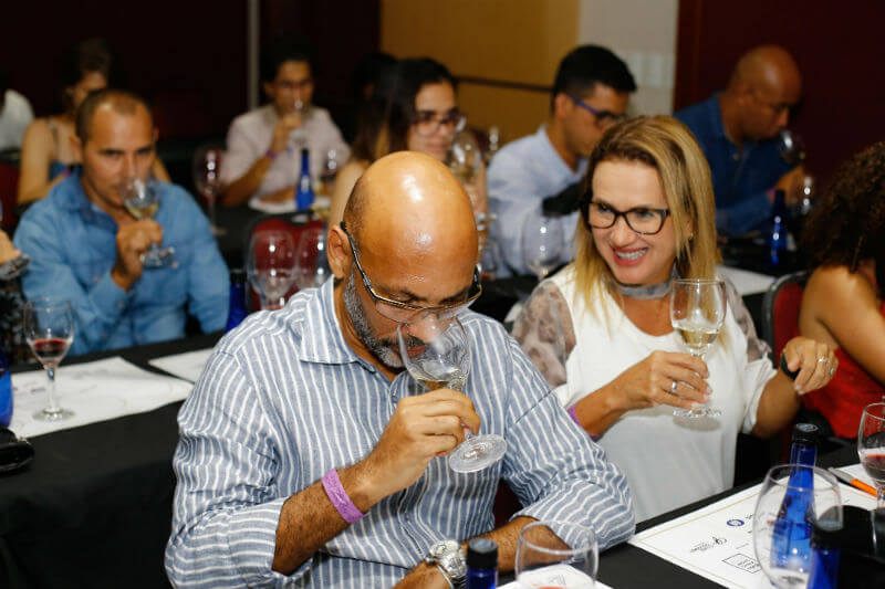 homem cheirando vinho dentro da taca