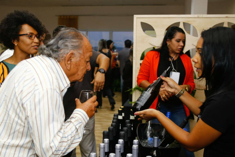 homem olhando vinho que a mulher está segurando