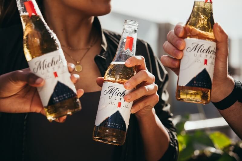 Pessoas brindando com a cerveja Michelob Ultra